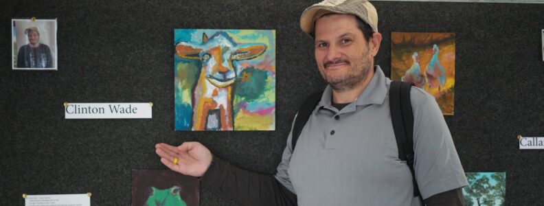 Amici House Artist Posing in Front of His Artwork